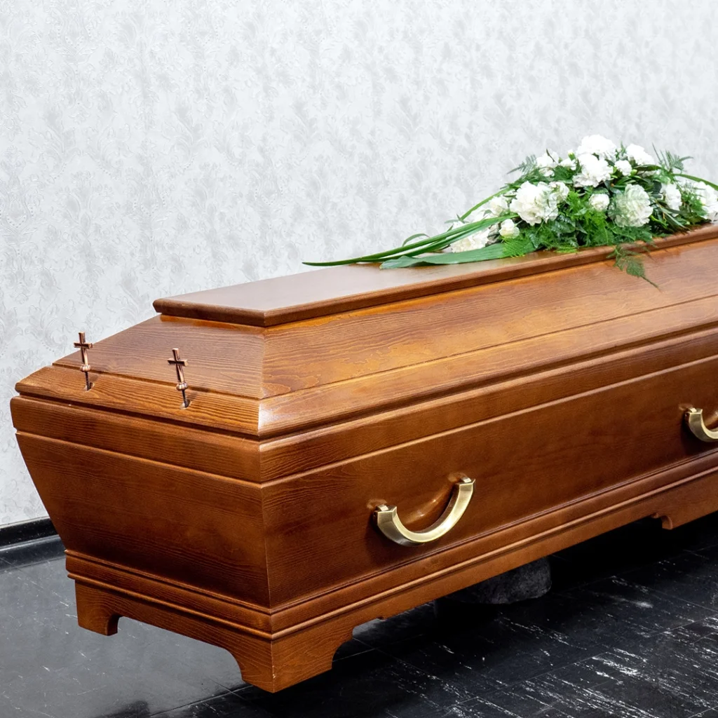 Ruskea puinen arkku jonka päällä on valkoinen kukkalaite